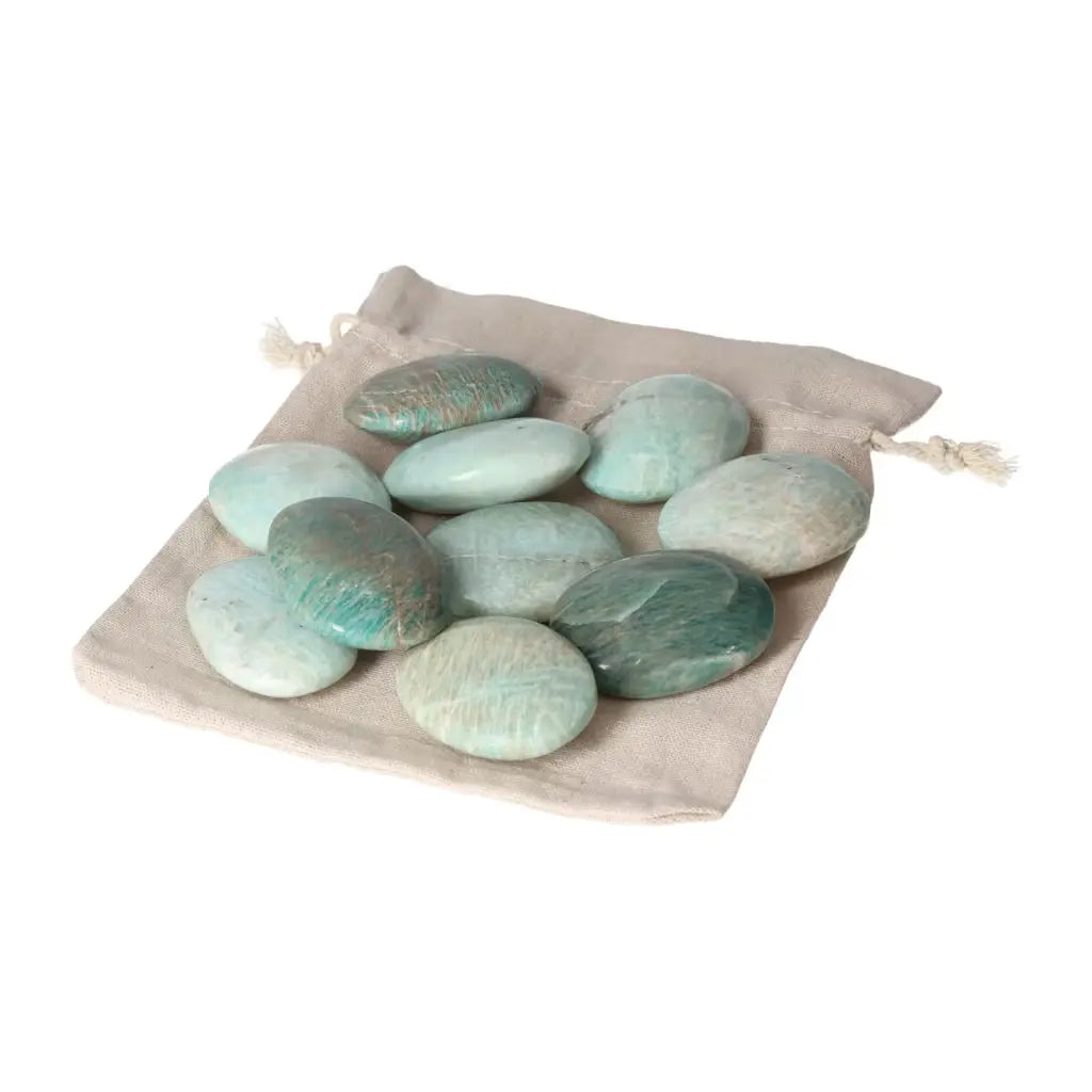 Assorted Amazonite Palm Stones on a beige drawstring pouch, showcasing calming energies and spiritual elegance from Sylvia Crystals.