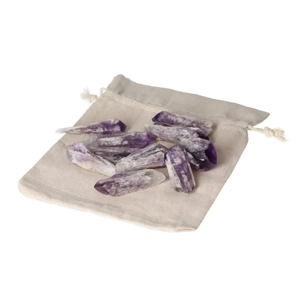 Amethyst Point S crystals from Sylvia Crystals displayed on a beige fabric pouch, enhancing tranquility and elegance in any space.