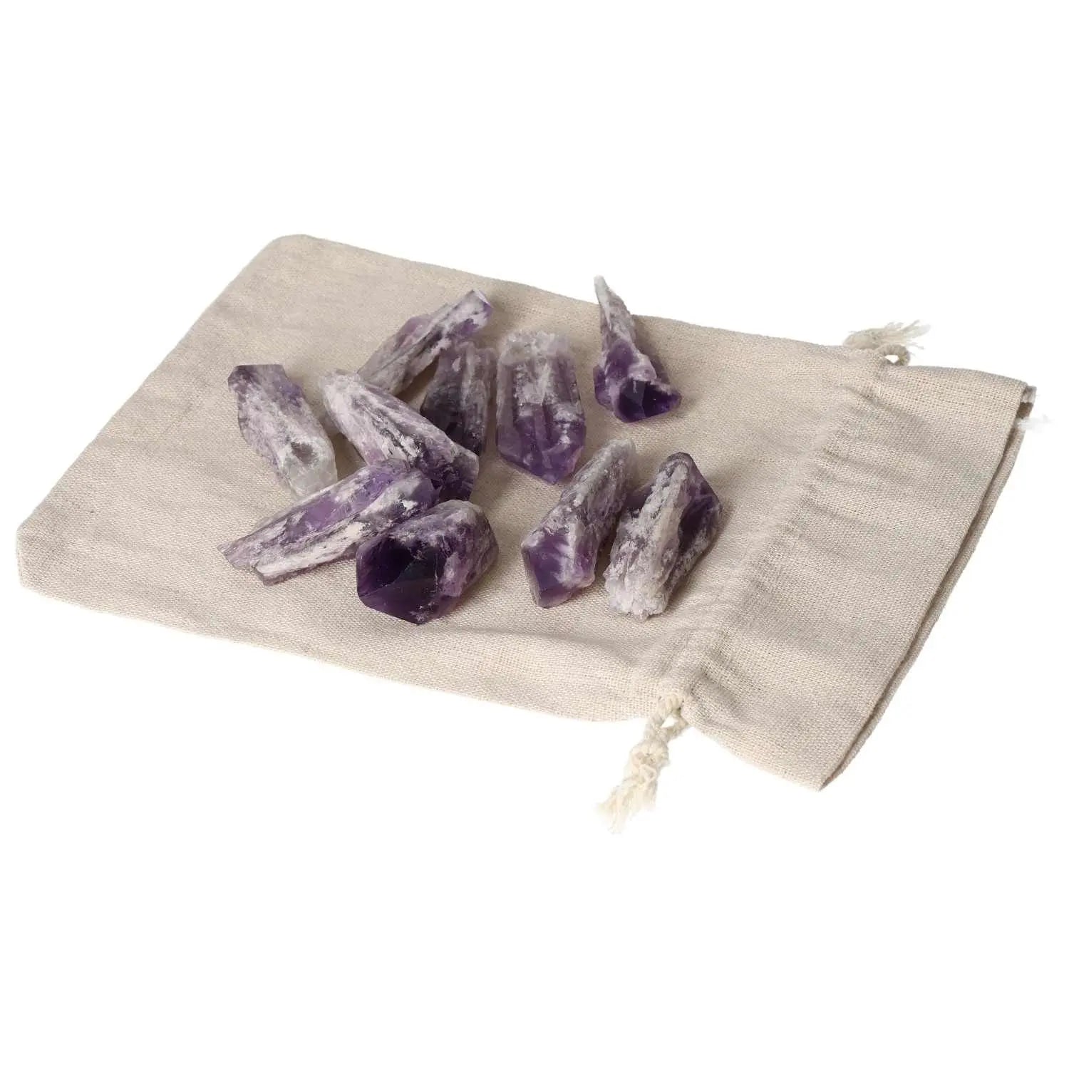 Collection of Amethyst Point S crystals from Sylvia Crystals on a beige cloth, enhancing tranquility and elegance in any space.
