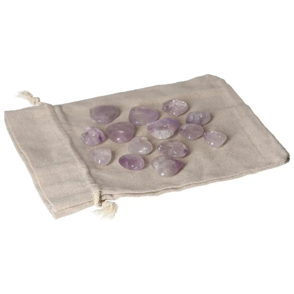 Small amethyst stones on a beige cloth pouch, known for stress reduction, energy boost, concentration enhancement, and emotional stability.