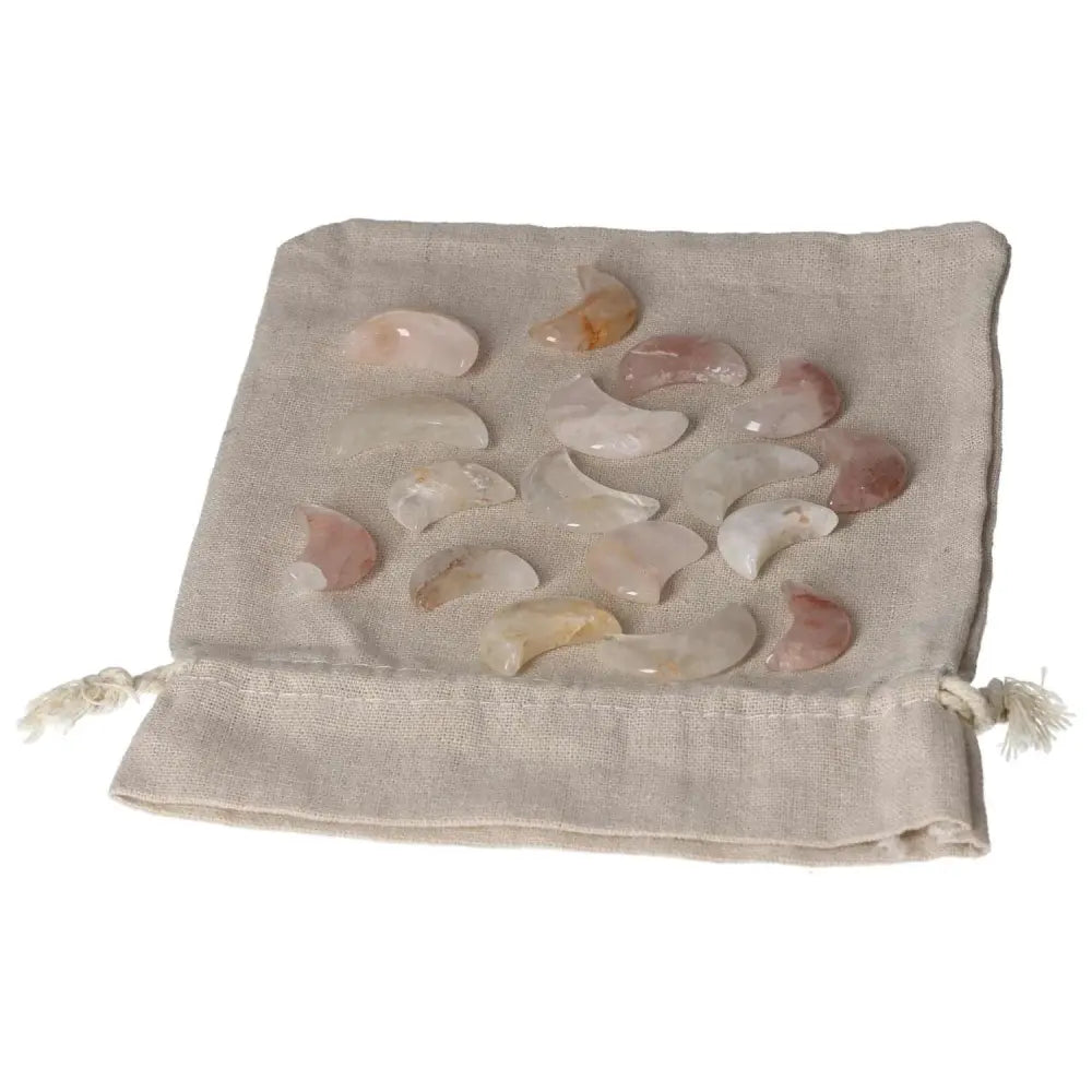 Collection of small Golden Healer moon-shaped crystals displayed on a fabric pouch