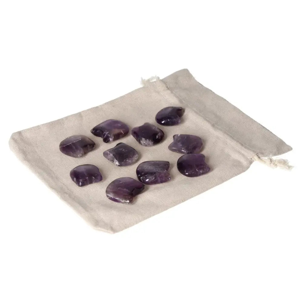 Amethyst small cat stones on a beige pouch, ideal for stress reduction, energy boost, and emotional stability. Enhances concentration.