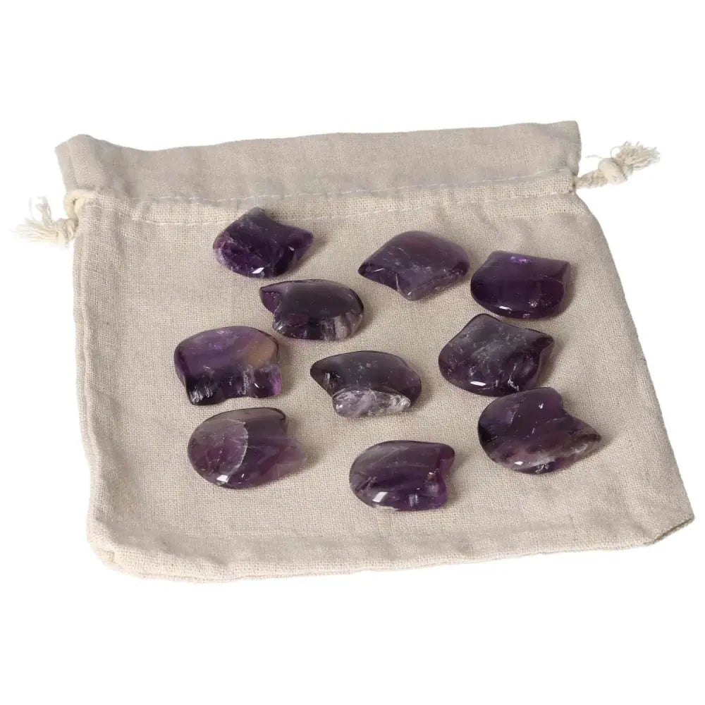 Small Amethyst stones on a beige pouch, known for stress reduction, energy boost, and enhancing concentration and emotional stability.