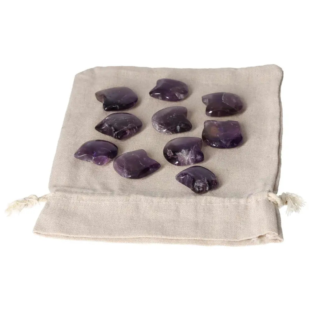 Amethyst small cat stones on a cloth, known for stress reduction, energy boost, concentration improvement, and emotional stability.