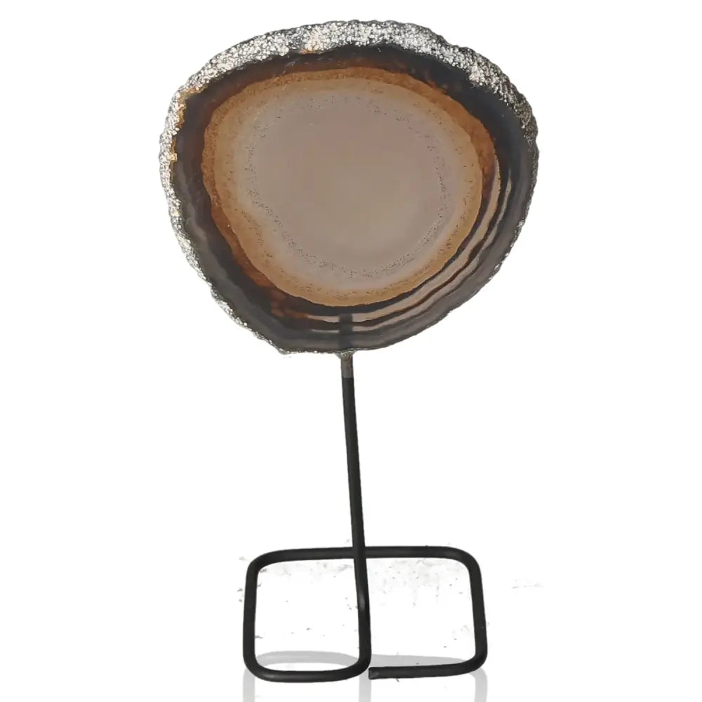 Agate slice on metal stand, showcasing natural beauty and adding tranquility to home decor with elegant, earthy tones.