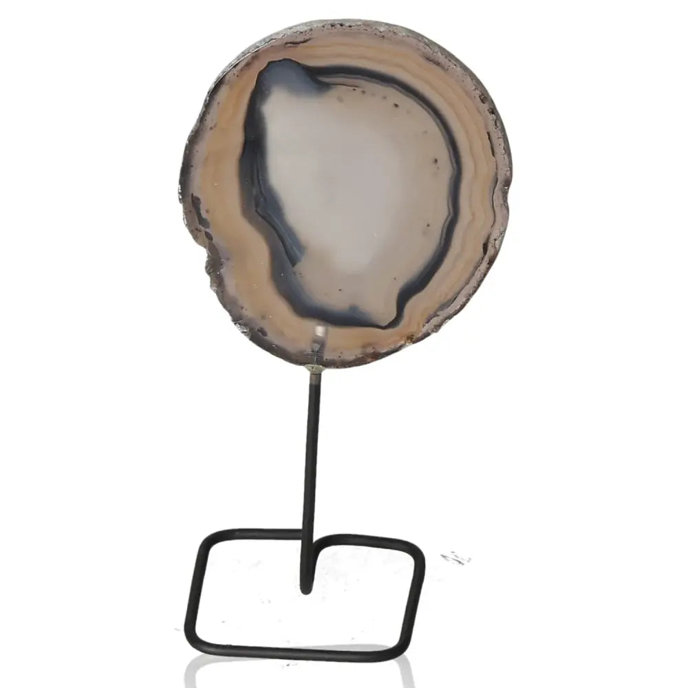 Agate slice with variegated hues on a metal stand, combining natural beauty with elegant design, perfect for enhancing decor.