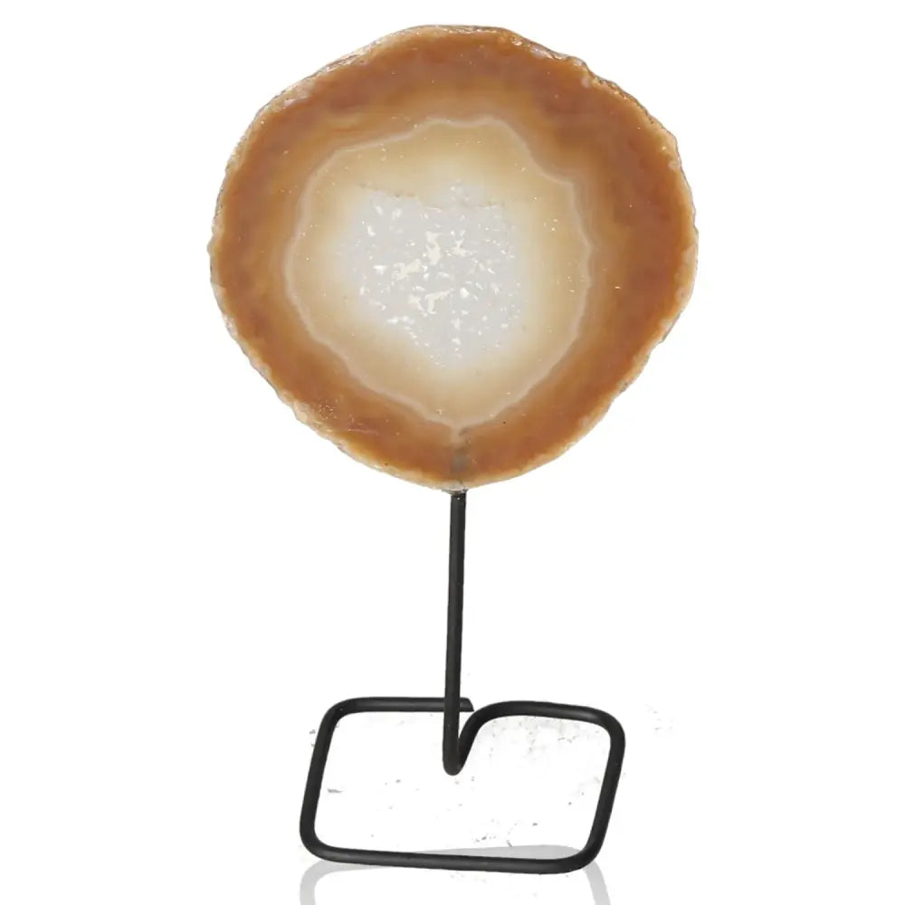 Agate slice on metal stand with unique patterns, serving as a decorative element enhancing personal well-being and home decor.