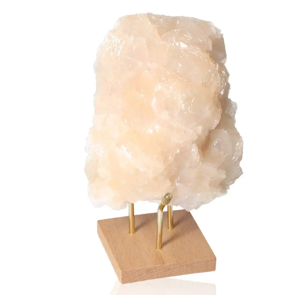 Honey Calcite stone on a wooden stand, promoting confidence and clarity; ideal for enhancing focus and motivation. Solar plexus aligned.