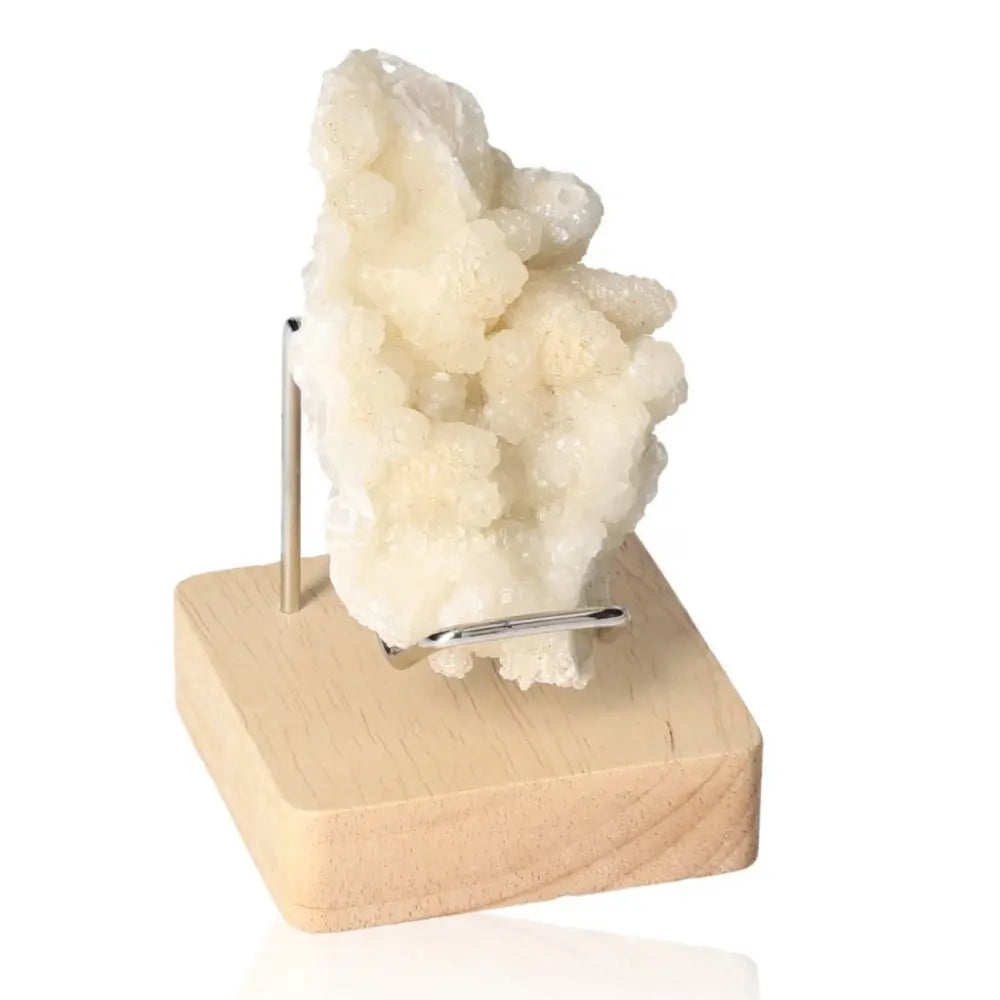 Calcite crystal on wooden stand showcasing vibrant hues and unique formations, ideal for enhancing spiritual growth and energy.