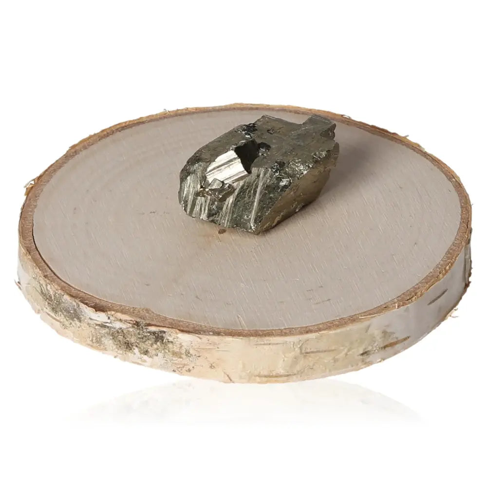 Golden pyrite stone on a wooden slab, showcasing its metallic luster and resemblance to gold, known as "Fool's Gold."