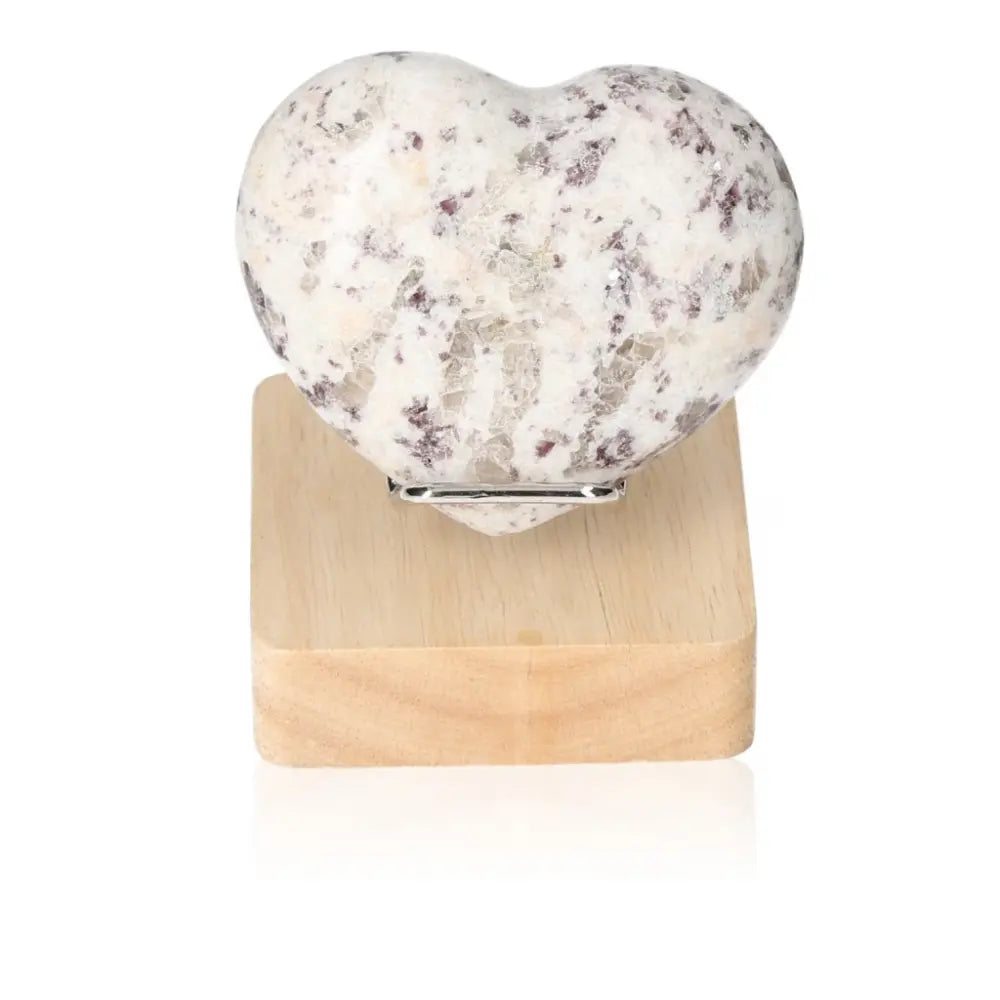 Heart-shaped Lepidolite stone on a wooden stand, promoting peace and emotional balance. Ideal for anxiety relief and positive energy.