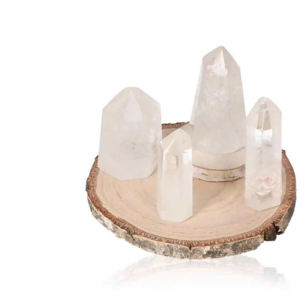 Set of crystal quartz points on a wooden base, ideal for crystal healing and home decor. Versatile and mystical energy tools.