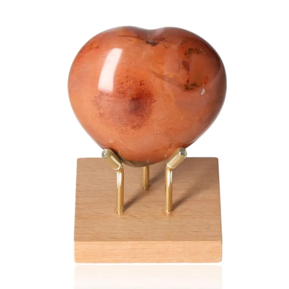 Heart-shaped carnelian gemstone displaying vibrant orange-red hues, ideal for jewelry, meditation, or home décor.