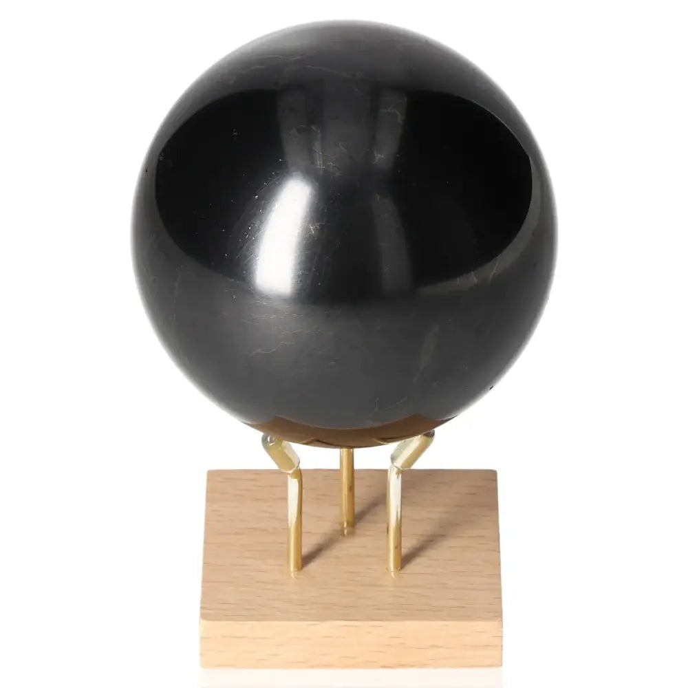Shungite Sphere 8 cm on stand by Sylvia Crystals, showcasing lustrous black surface and elegant craftsmanship.