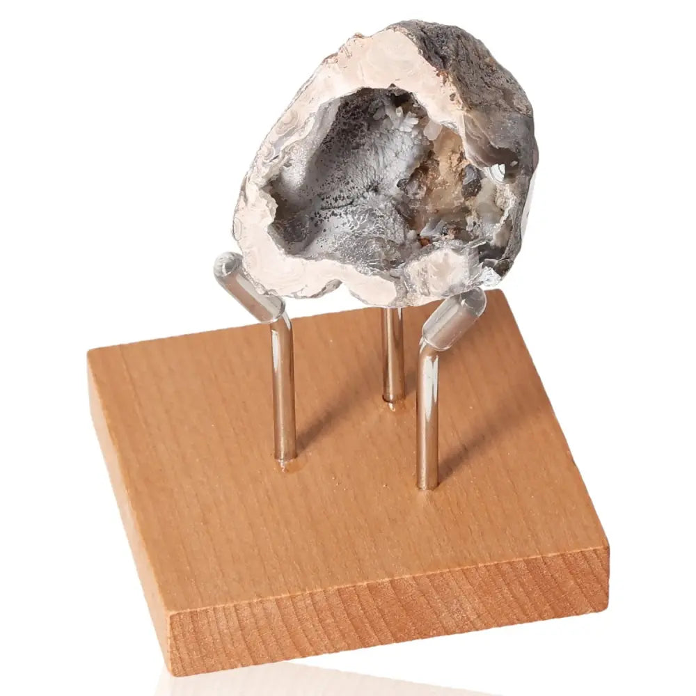 Mini Agate Geode on wooden stand, showcasing intricate patterns and rich hues for tranquility and harmony.