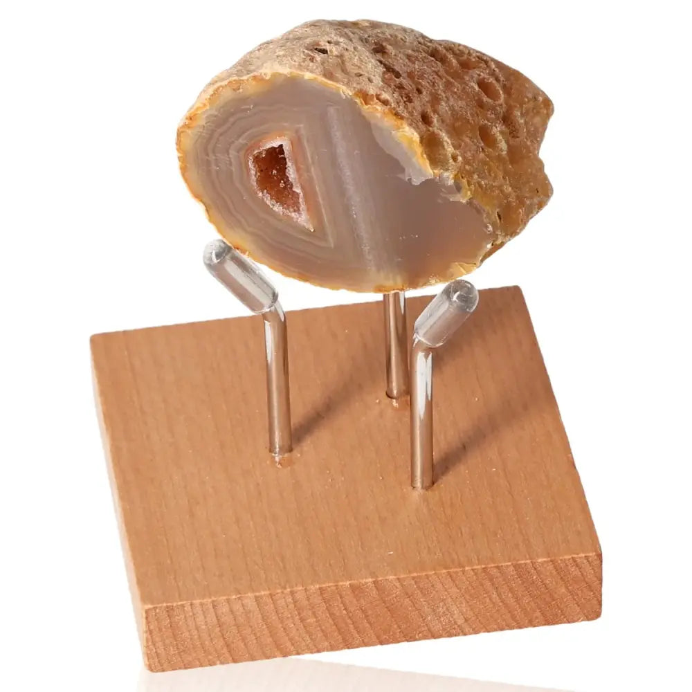 Mini Agate Geode on wooden stand showcasing intricate patterns and colors, ideal for enhancing tranquility and well-being.