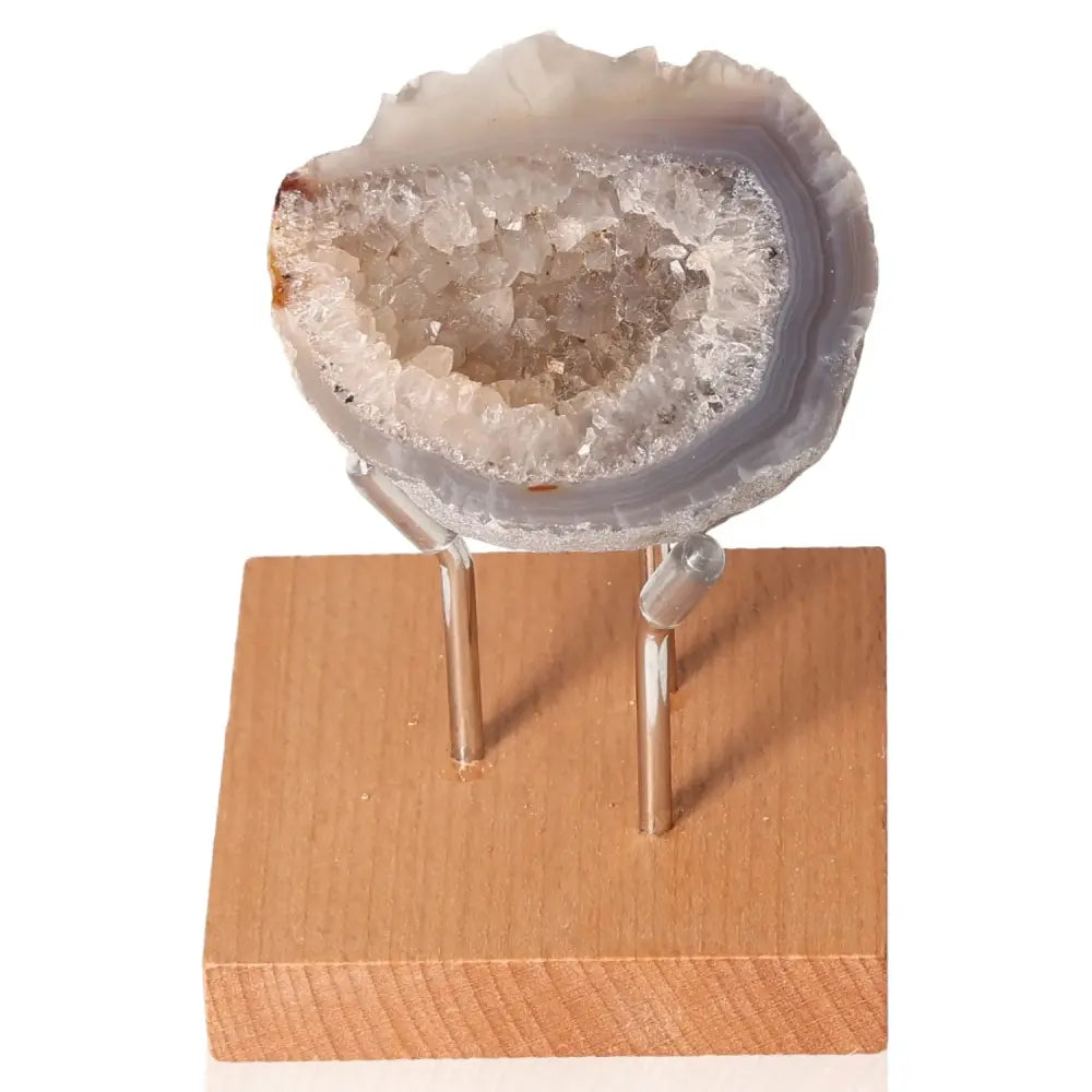 Mini Agate Geode gemstone on a wooden stand, showcasing intricate patterns and natural beauty, ideal for harmonizing and balancing spaces.