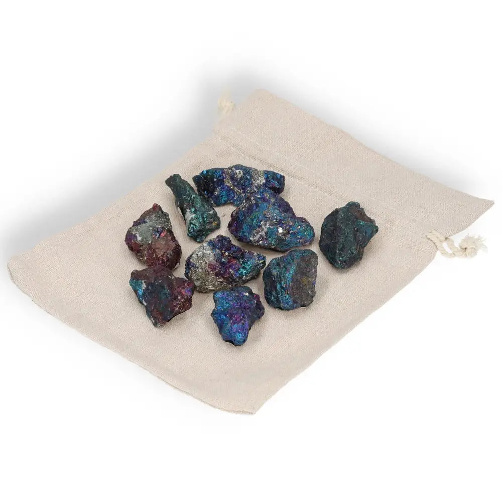 Assorted colored chalcopyrite stones on a fabric pouch, showcasing vibrant iridescent hues for spiritual healing and enlightenment.