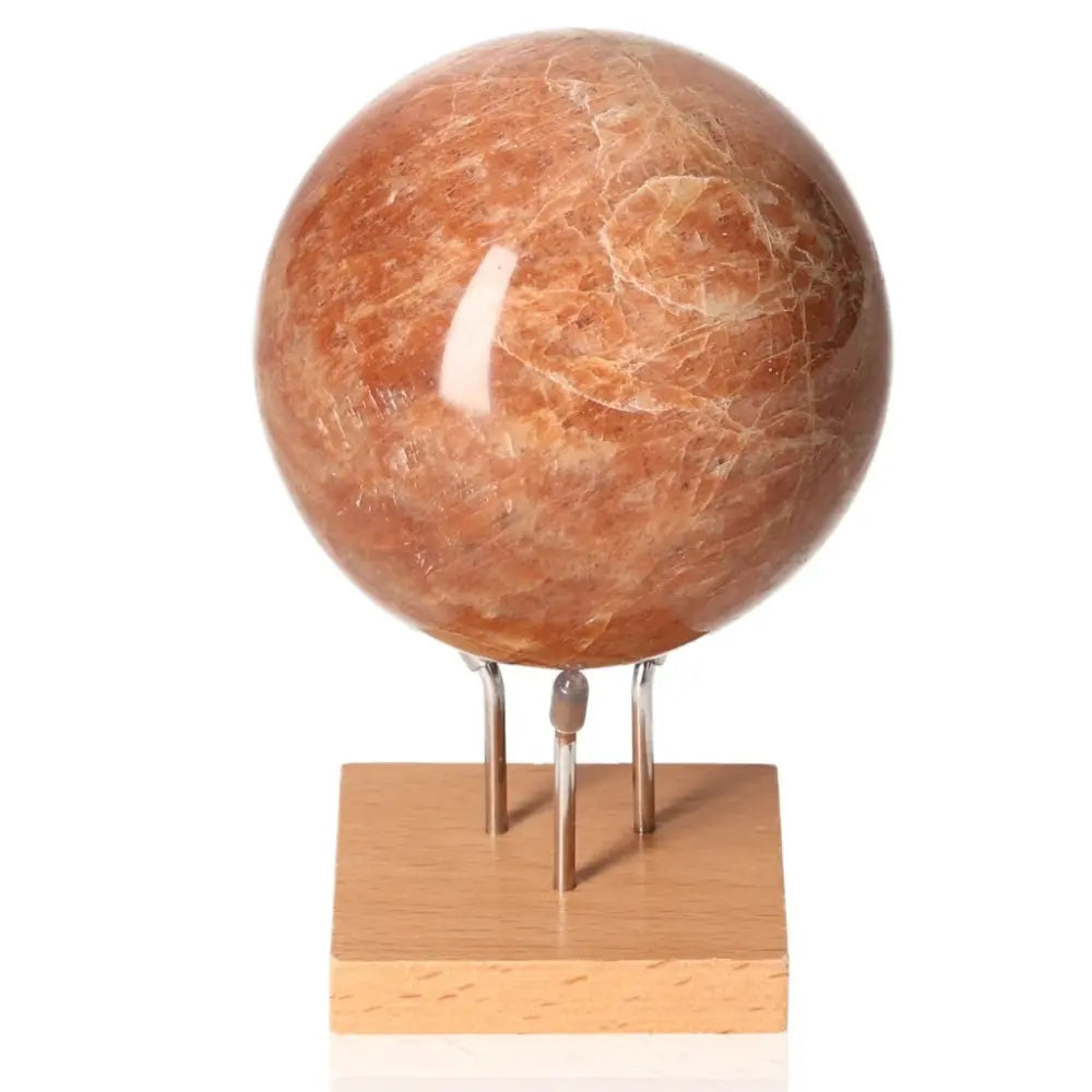 Peach Moonstone Sphere on stand, promotes emotional balance and intuition, ideal for enhancing attractiveness and ensuring restful sleep.