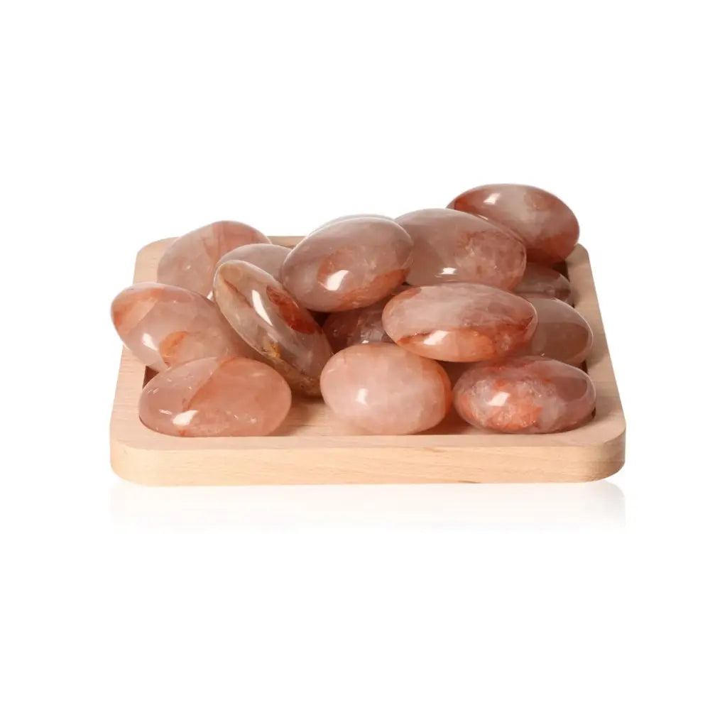 Hematoid Palm Stone XL on a wooden tray, showcasing its unique quartz variations that support chakras and zodiac energies.