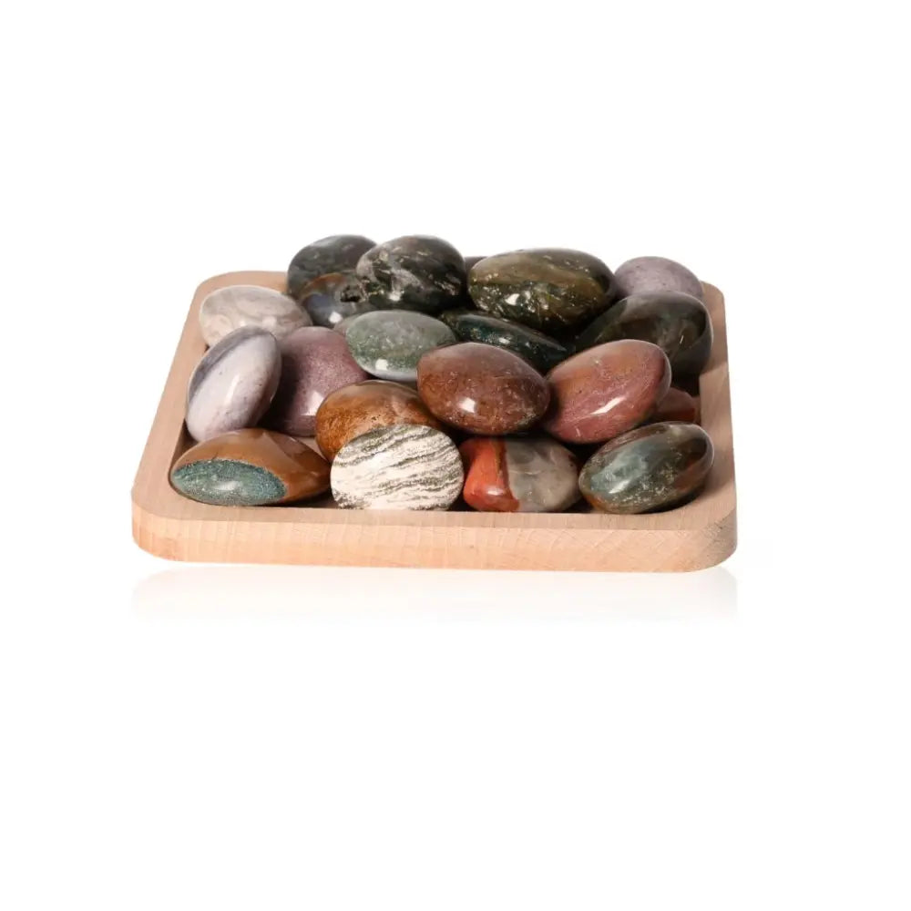 Assorted Ocean Jasper Palm Stones in a wooden tray, showcasing natural patterns and colors for emotional stability and positivity.