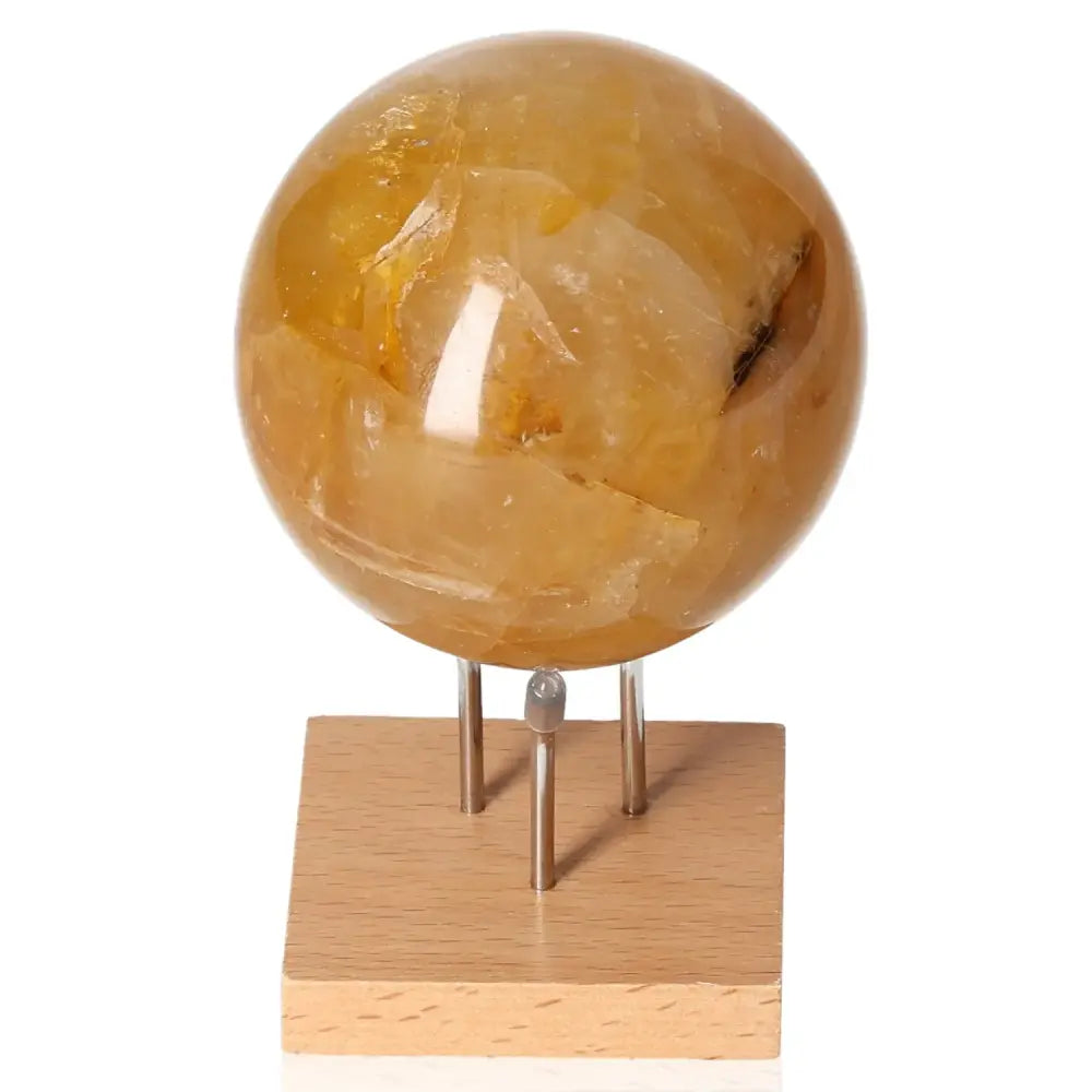 Honey Calcite Sphere on wooden stand, symbolizing confidence, clarity, and motivation. Enhances focus and aligns with solar plexus chakra.