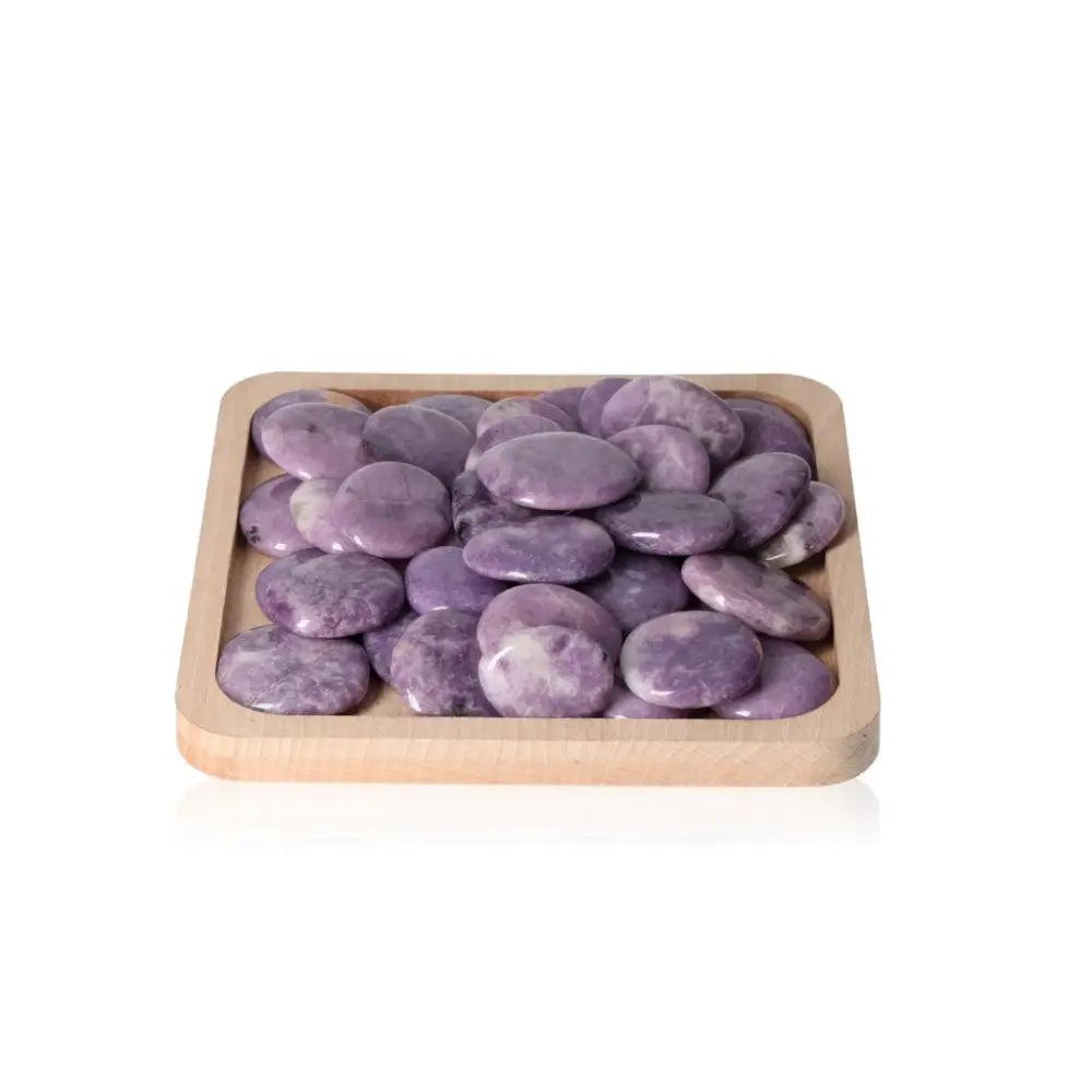 Lepidolite palm stones in a wooden tray, offering peace, emotional balance, and soothing energy for anxiety relief and positive outlook.