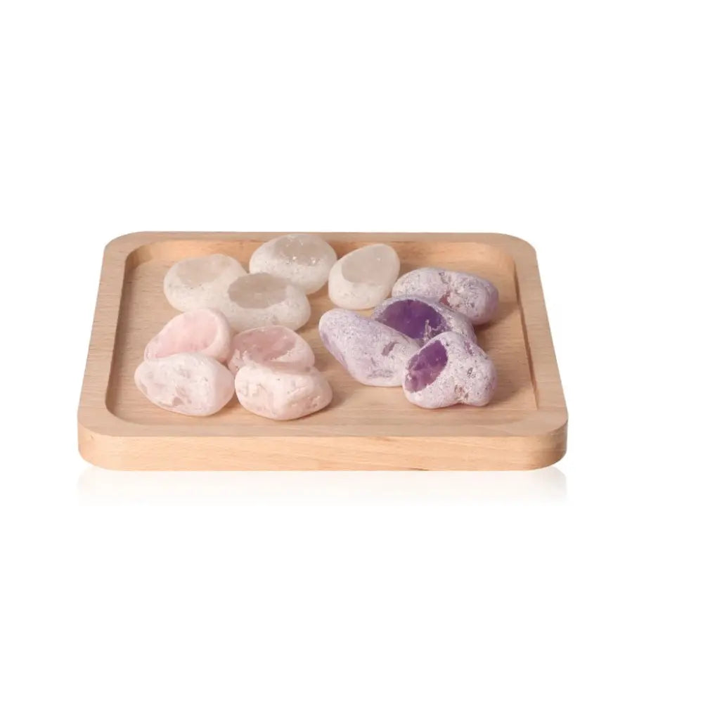 Smooth Emma Eggs stones on a wooden tray, featuring natural hues and polished surfaces for balance and harmony.