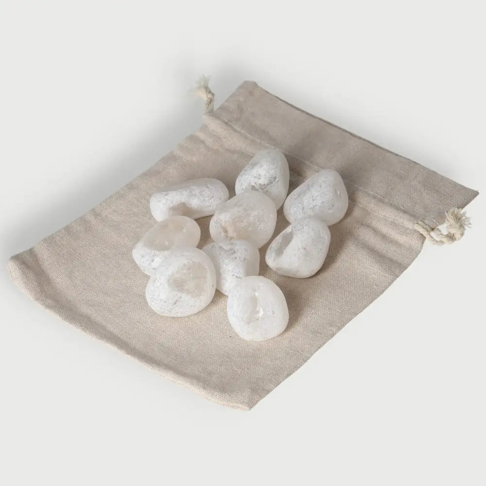 Set of Emma Eggs or Ema River Stones on a tan drawstring pouch, showcasing smooth, oval-shaped stones for balance and harmony.