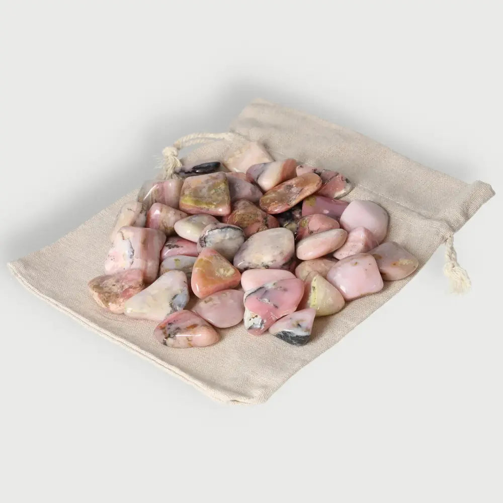 Tumbled opal crystals in a drawstring bag, enhancing love and cosmic consciousness, perfect for motivation and rekindling passion.