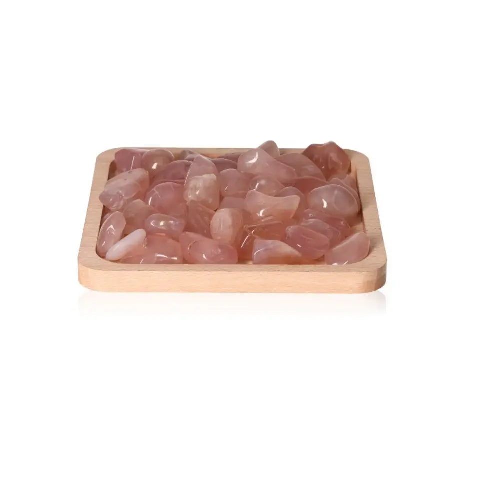 Pink Chalcedony crystals from Sylvia Crystals, promoting emotional balance and positive thinking, displayed on a wooden tray.