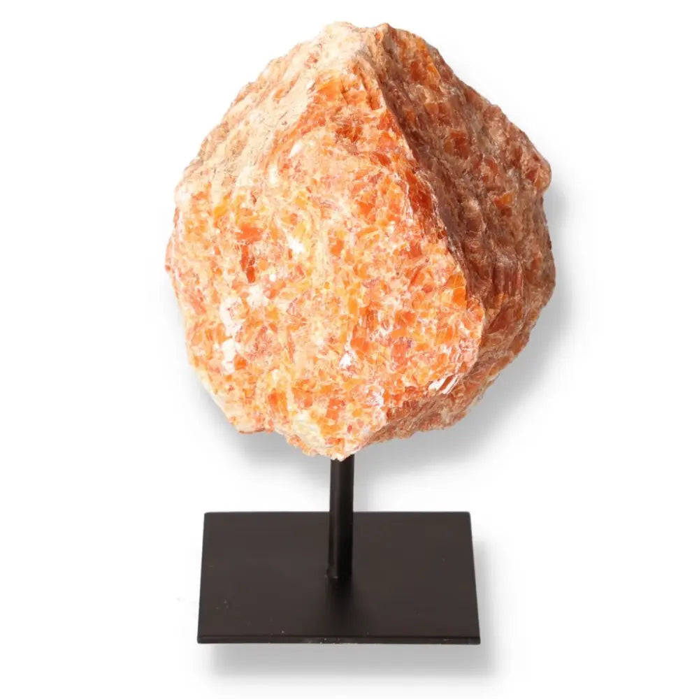 Orchid Calcite stone with vibrant orange and pink hues on a sleek metal stand, symbolizing creativity, motivation, and emotional strength.
