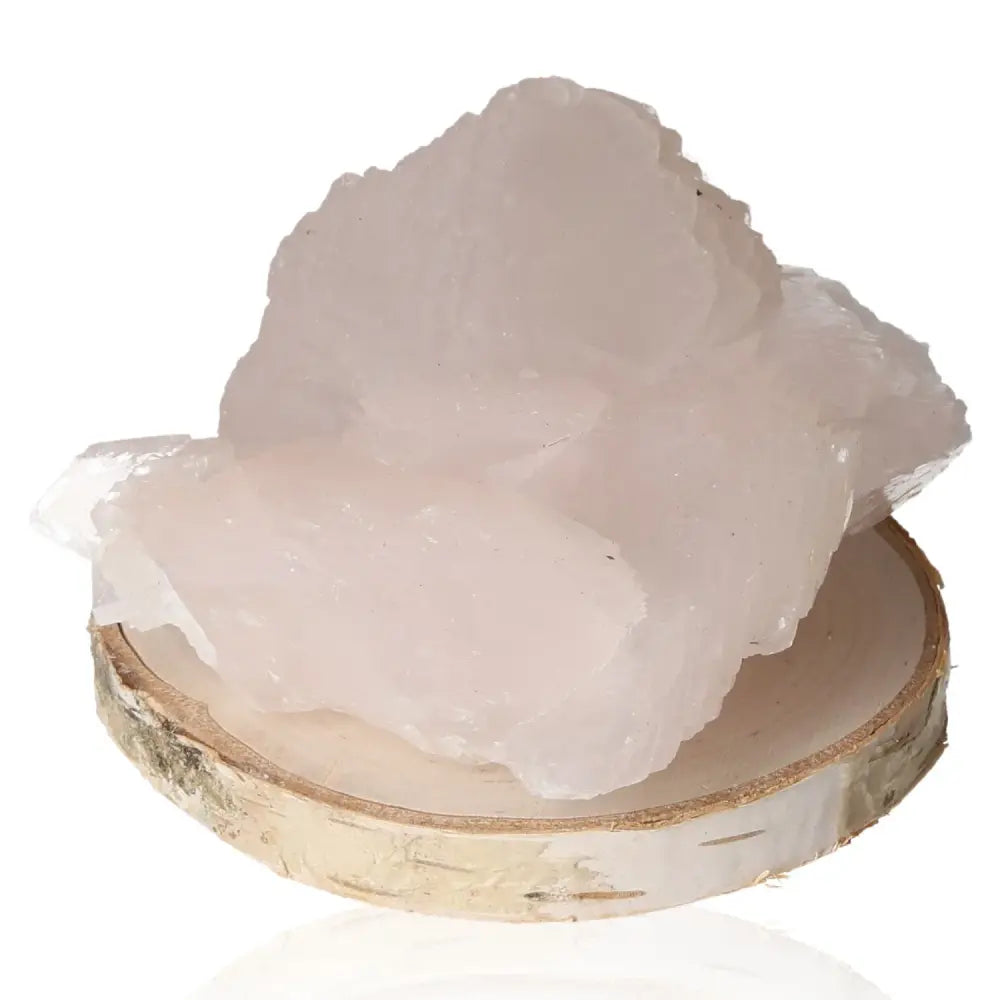 Manganocalcite stone, known for love, compassion, emotional healing, displayed on a wooden base