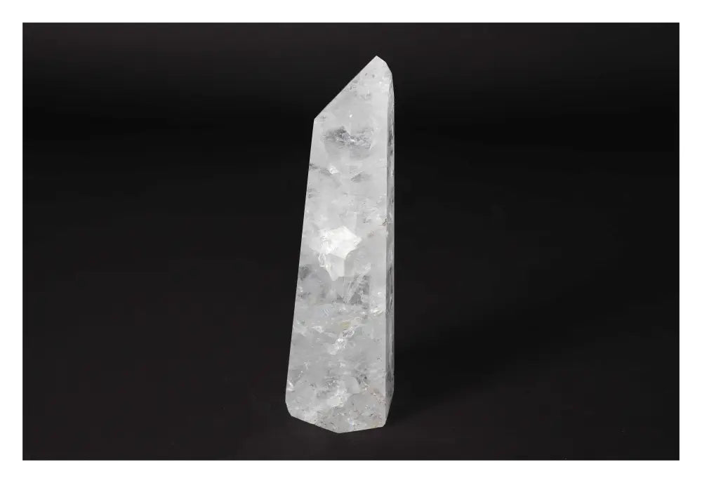 Premium clear crystal quartz point from Sylvia Crystals, showcasing spiritual and energetic harmony against a dark background.