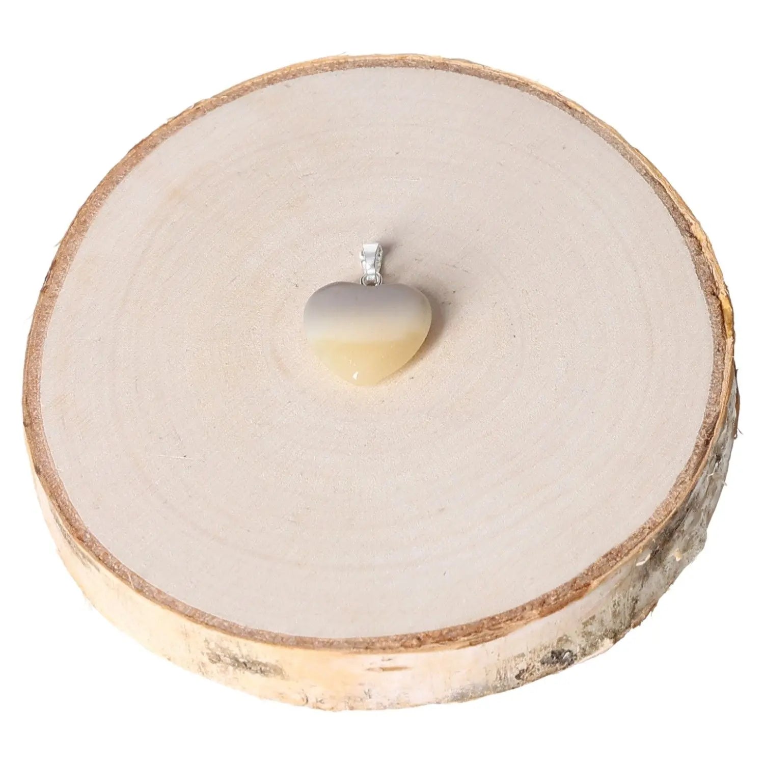 Heart-shaped 15mm grey agate pendant displayed on a rustic wood slice, highlighting its elegant and soothing design.