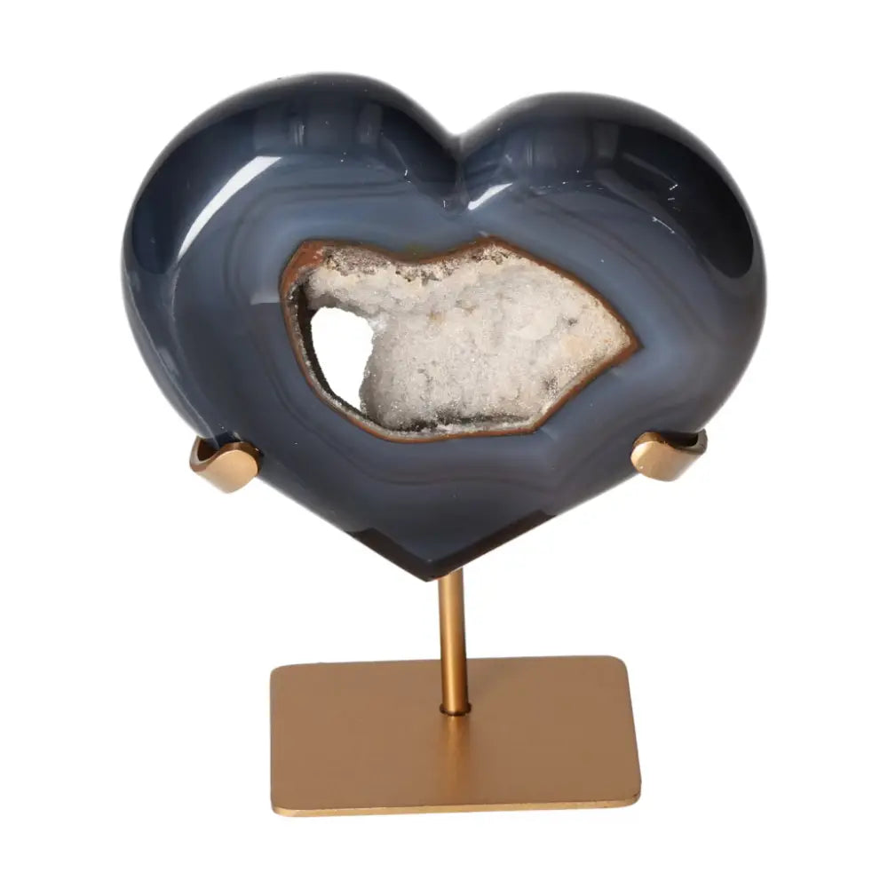 Elegant agate heart crystal on gold stand, designed by Sylvia Crystals, known for energy harmonizing and luxurious decor.