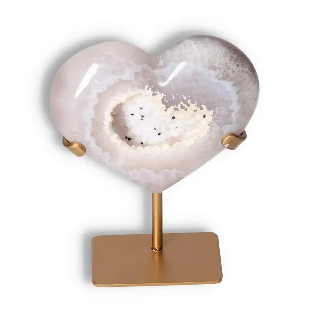 Agate Heart crystal on gold stand, showcasing unique patterns and energy harmonizing properties by Sylvia Crystals.