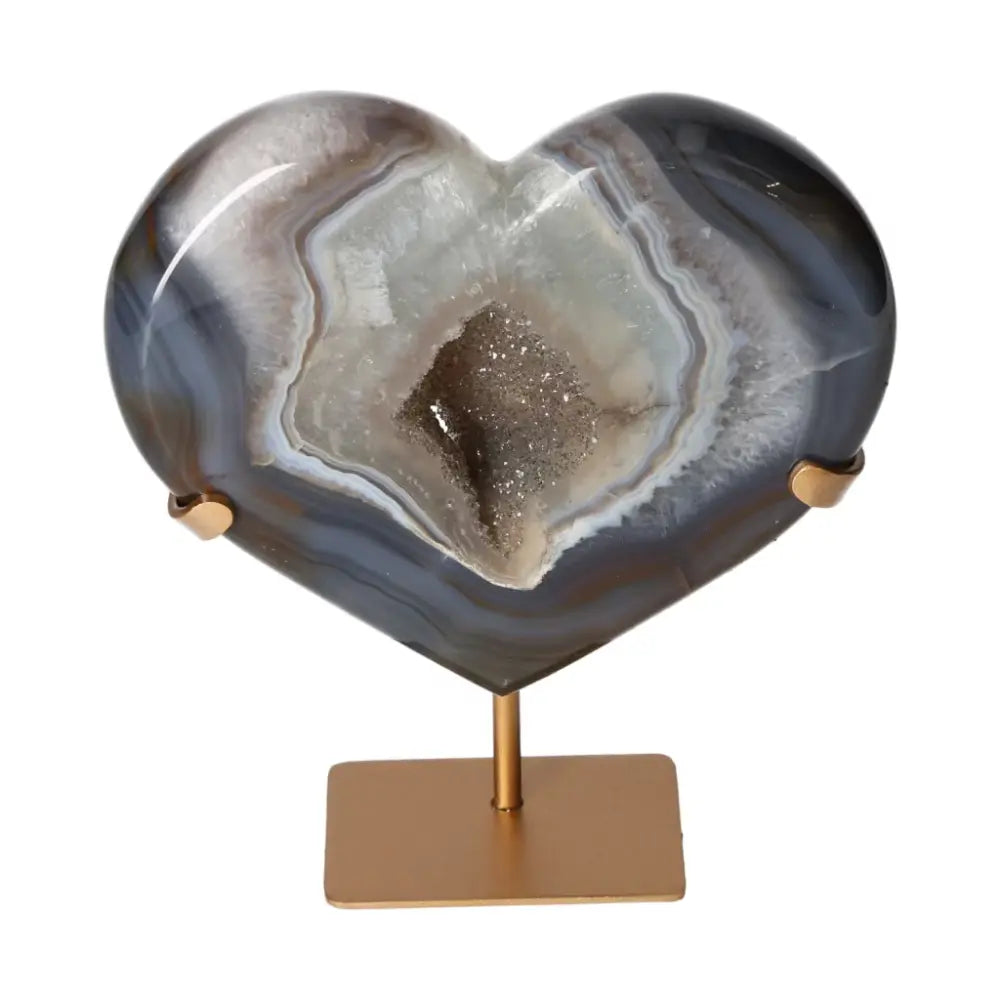 Elegant agate heart with unique patterns and crystalline formations displayed on a stand, showcasing natural beauty and elegance.