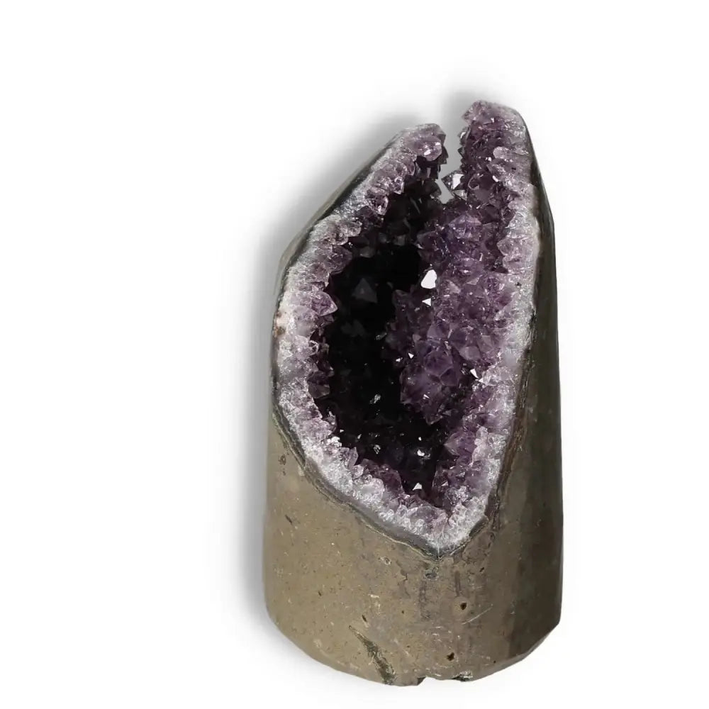 Amethyst Cut Base Geode by Sylvia Crystals, featuring vibrant purple crystals and a natural stone exterior, promoting tranquility and balance.