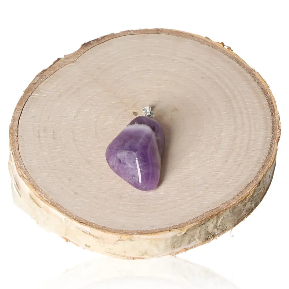 Amethyst Malawi Tumbled Pendant featuring a genuine deep purple amethyst stone, symbolizing healing and tranquility, on a wooden background.