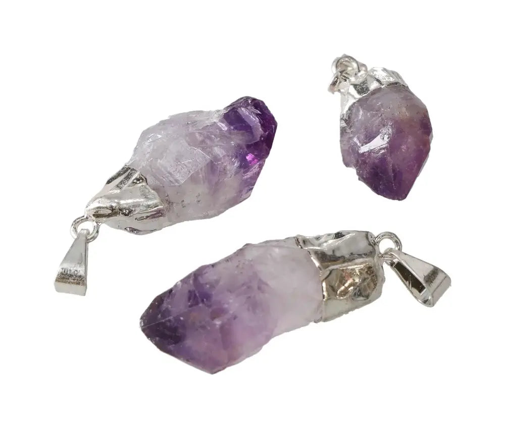 Three small silver amethyst point pendants with clear and purple crystal formations displayed on a white background.