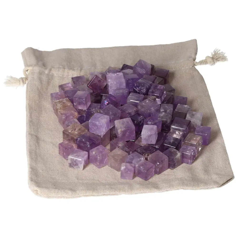 Pile of amethyst small cubes on a linen bag, designed to reduce stress, boost energy, enhance concentration, and promote emotional stability.