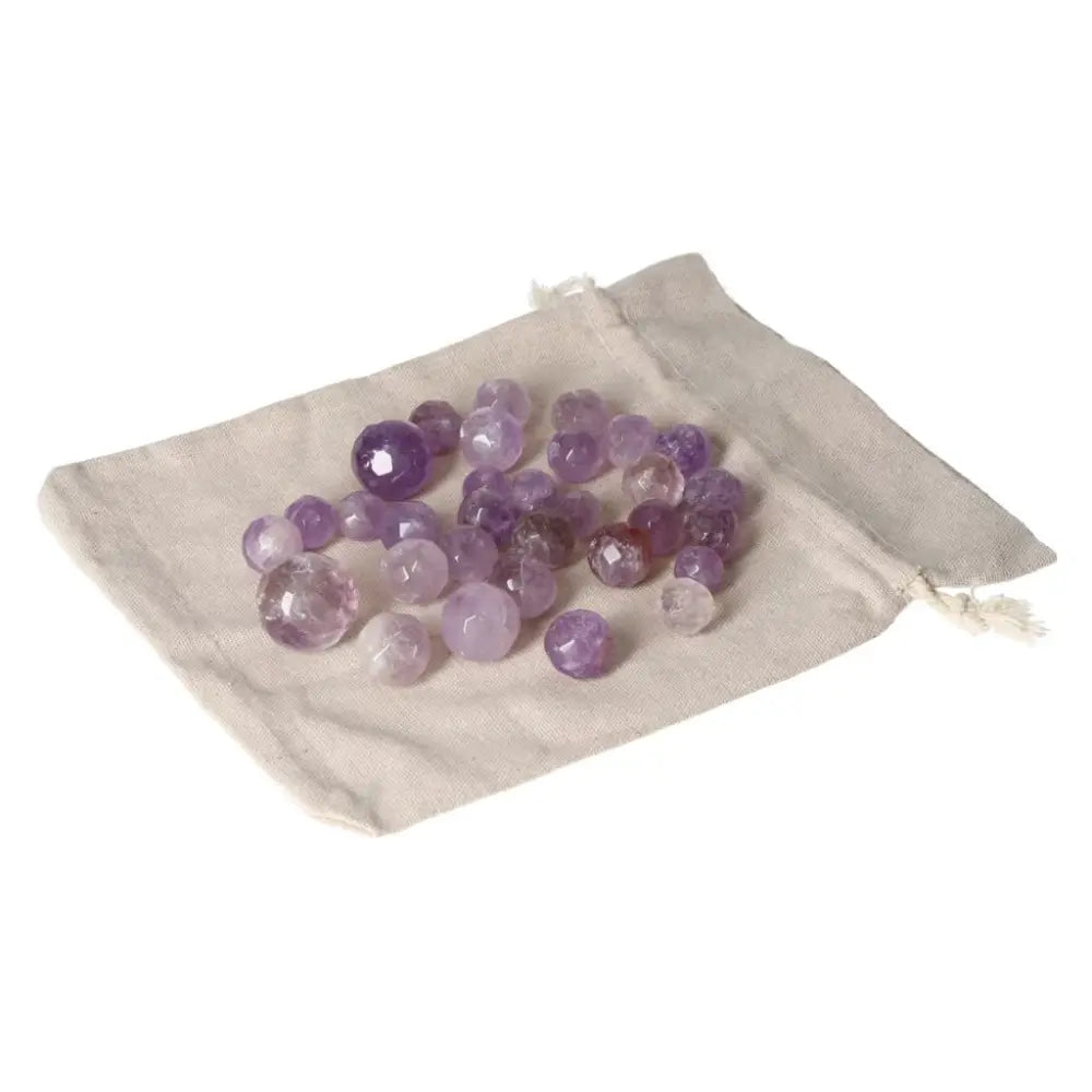 Amethyst small geometric spheres in a beige fabric pouch, known for enhancing concentration, reducing stress, and boosting energy.