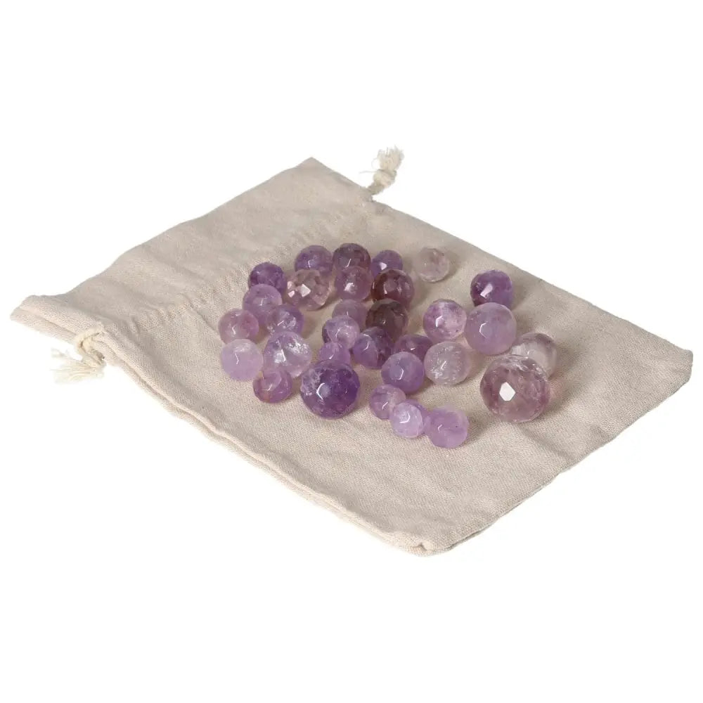 Amethyst small geometric spheres on a beige cloth, enhancing concentration and emotional stability, perfect for stress reduction and energy boost.