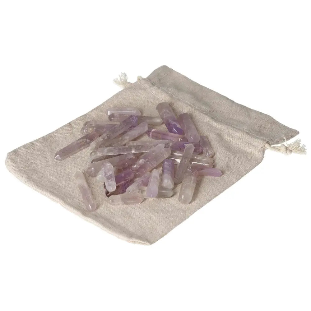 Amethyst small stics on a beige drawstring bag, known for reducing stress and enhancing concentration.