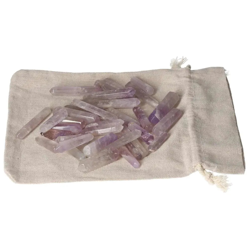 Amethyst small sticks for stress reduction, energy boost, and concentration enhancement, displayed on a fabric pouch.