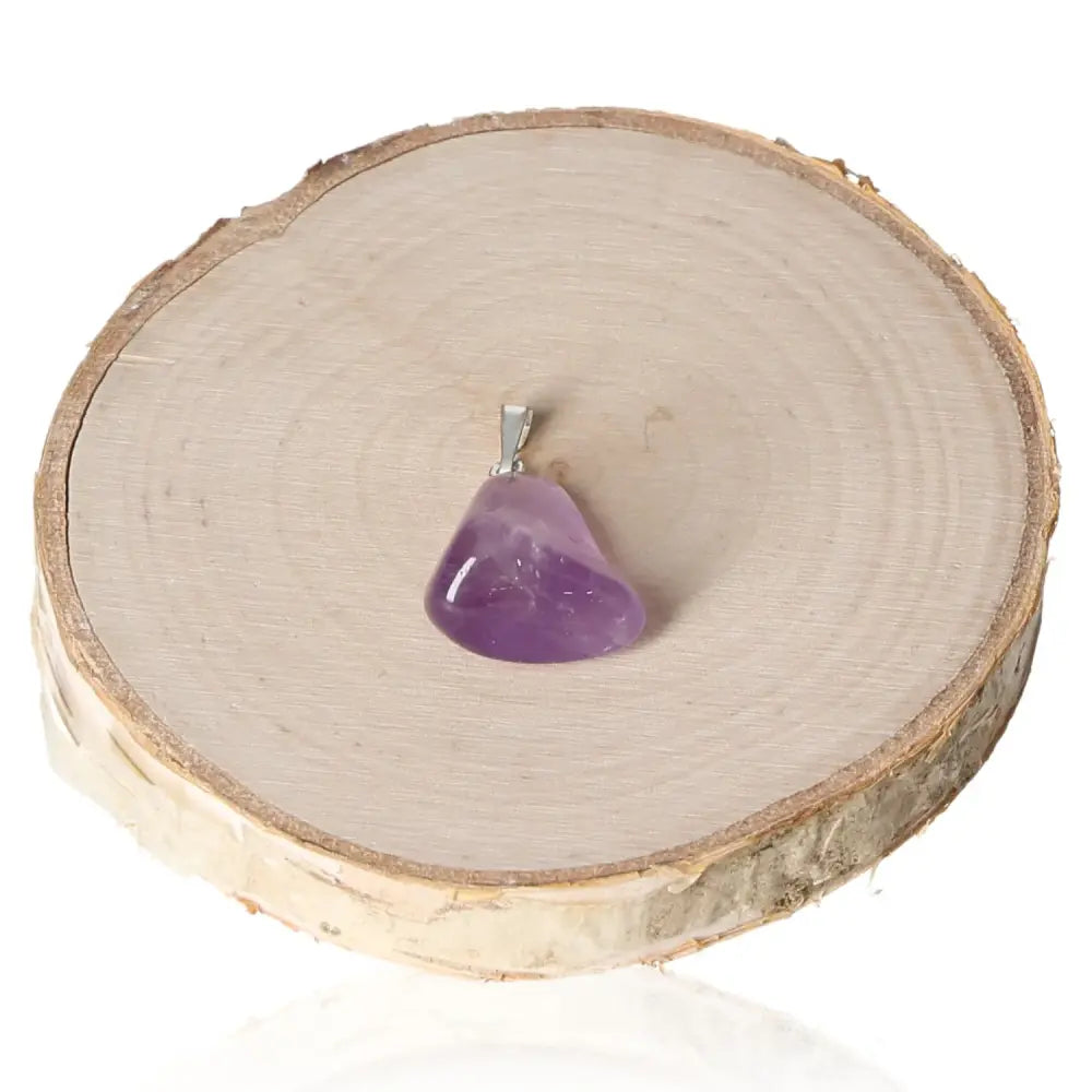 Amethyst Tumbled Pendant on wooden slice, showcasing its natural beauty and elegant design. Ideal for adding sophistication to your collection.