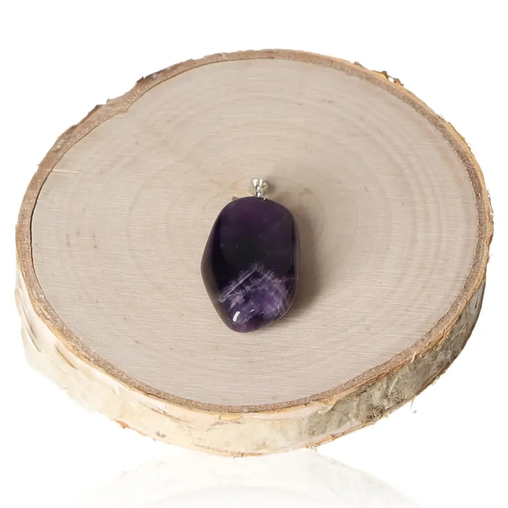 Amethyst Zambia Tumbled Pendant displaying natural beauty and serenity on a wooden surface