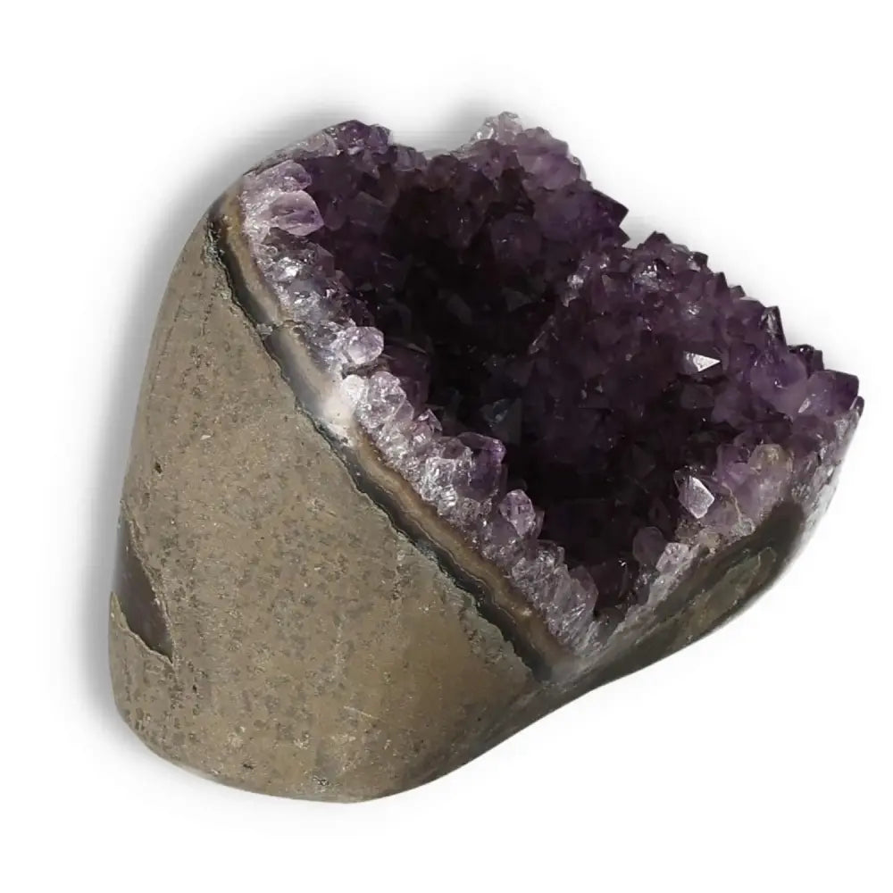 Amethyst cut base geode from Sylvia Crystals, showcasing purple crystals and a natural stone base for elegance and stress relief.