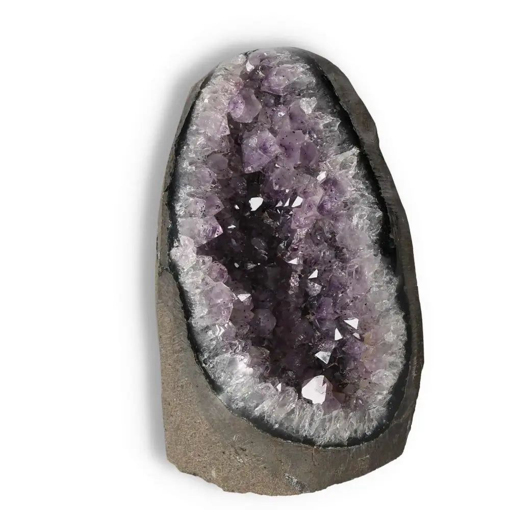Amethyst cut base geode from Sylvia Crystals, showcasing deep purple hues and crystal formations for stress relief and focus enhancement.